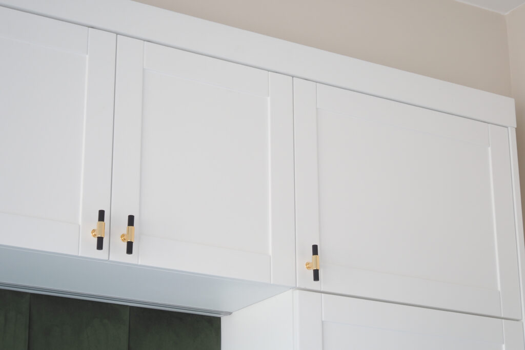 White Frameless Kitchen Cabinet with black and gold handle bar